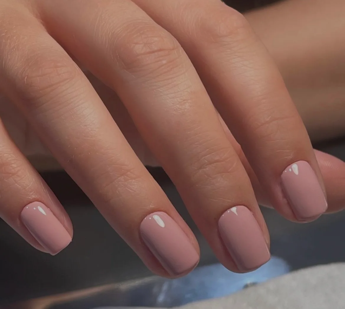A glossy, soft pink manicure photographed by Jen Peachey