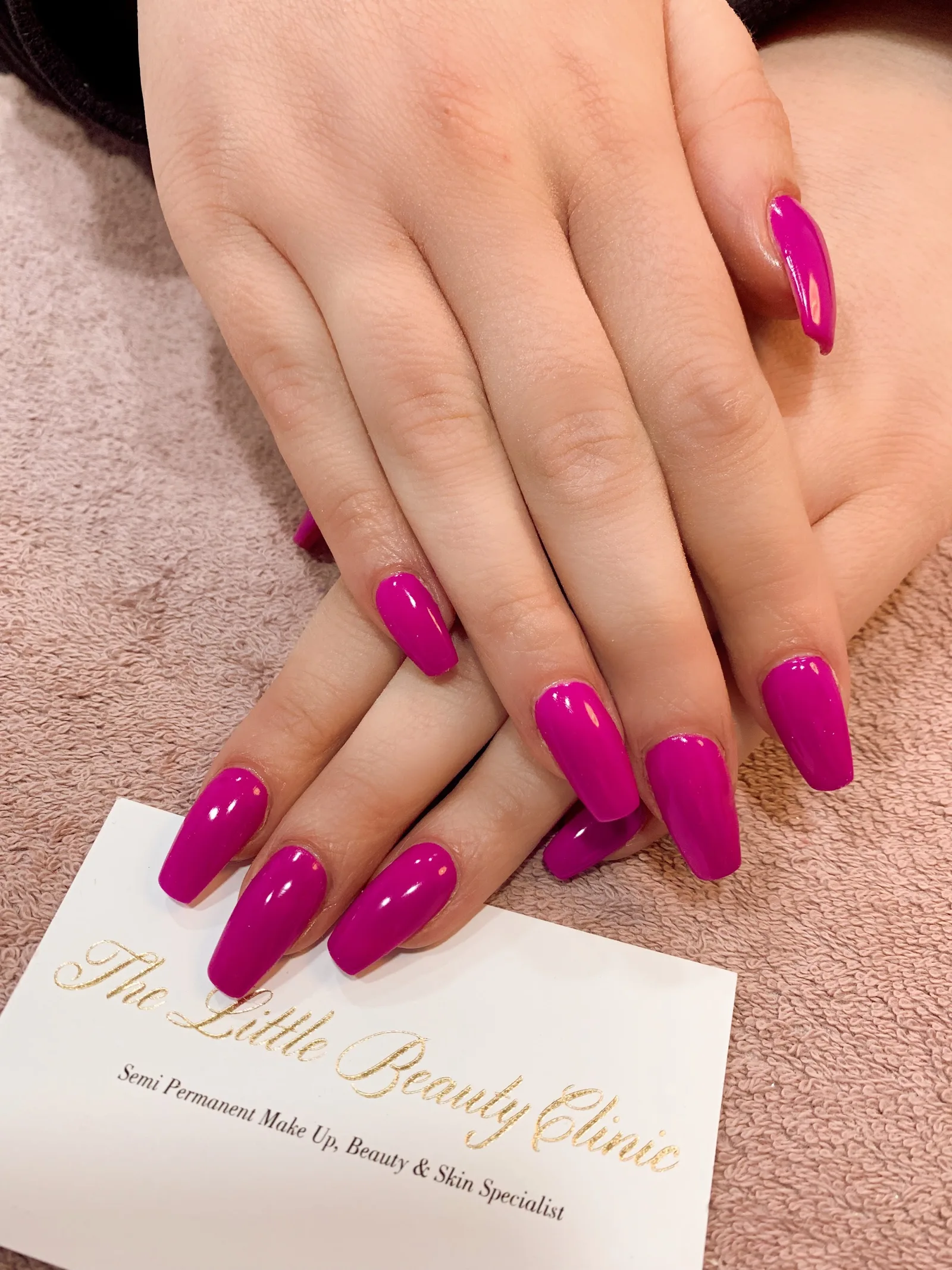 Bright magenta manicure with The Little Beauty Clinic's branded card