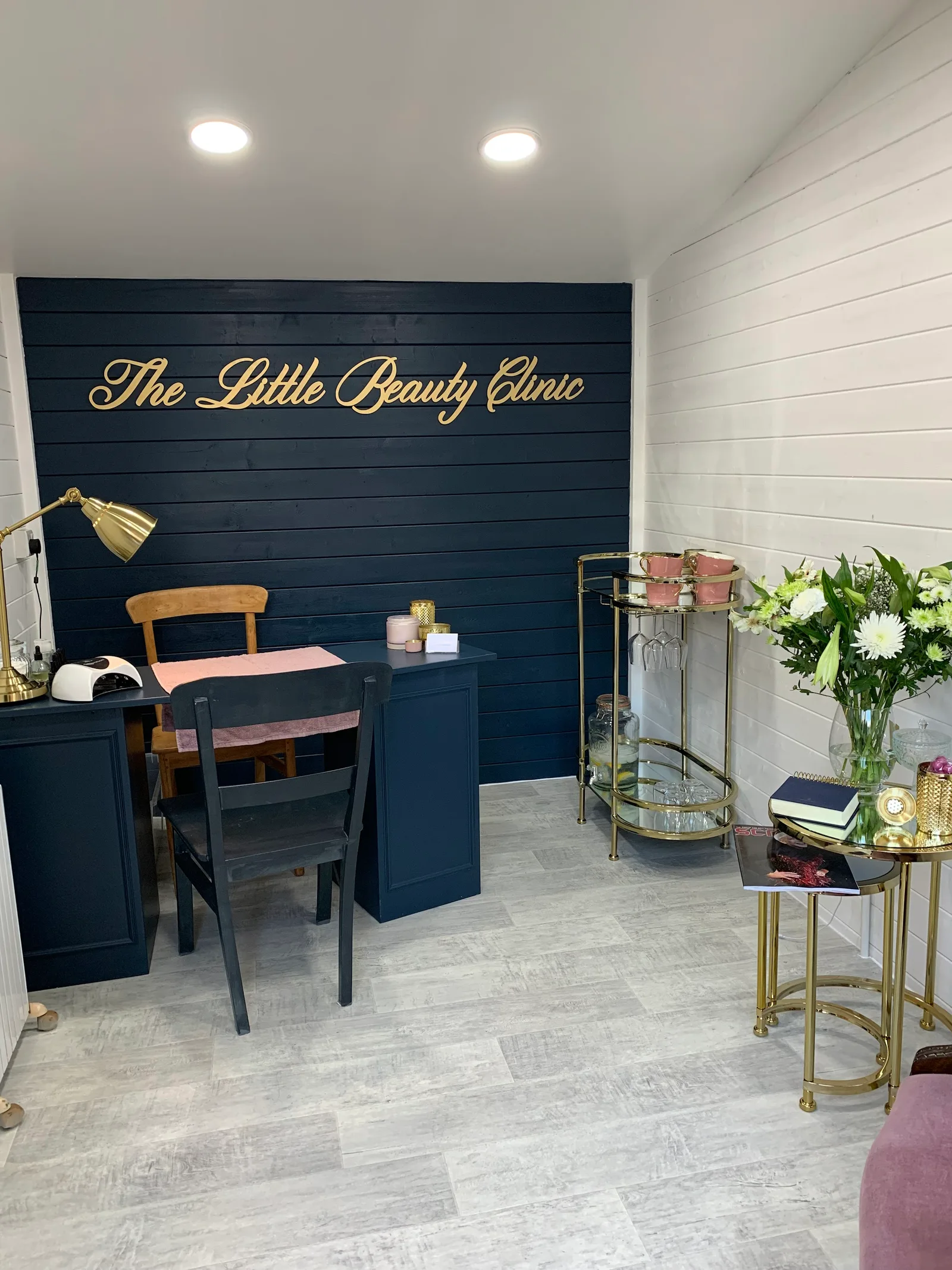 Inside The Little Beauty Clinic, with gold lettering, a manicure desk and navy panelling
